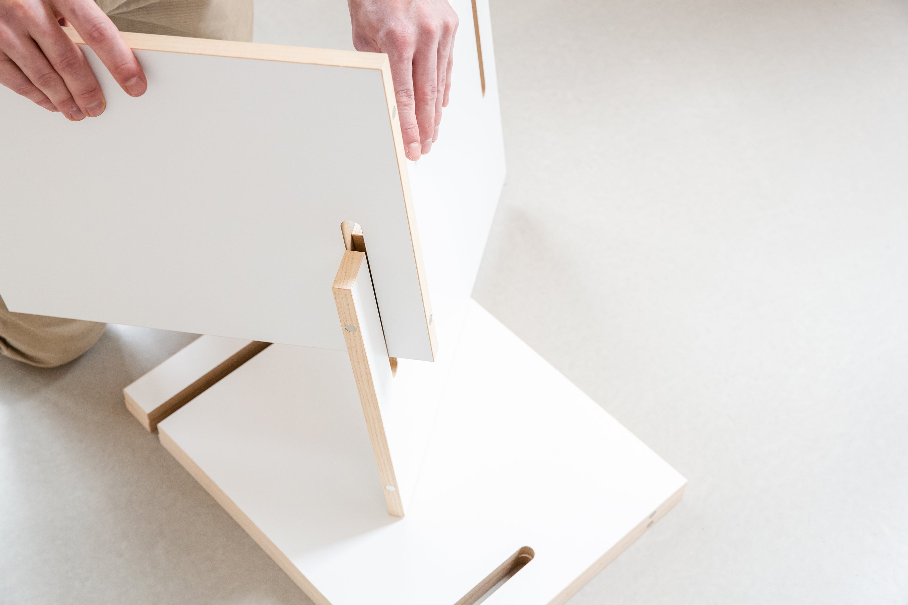 Regalteile werden zu einem Würfelregal zusammengesteckt. Es ist der Aufbau des Regals zu sehen.