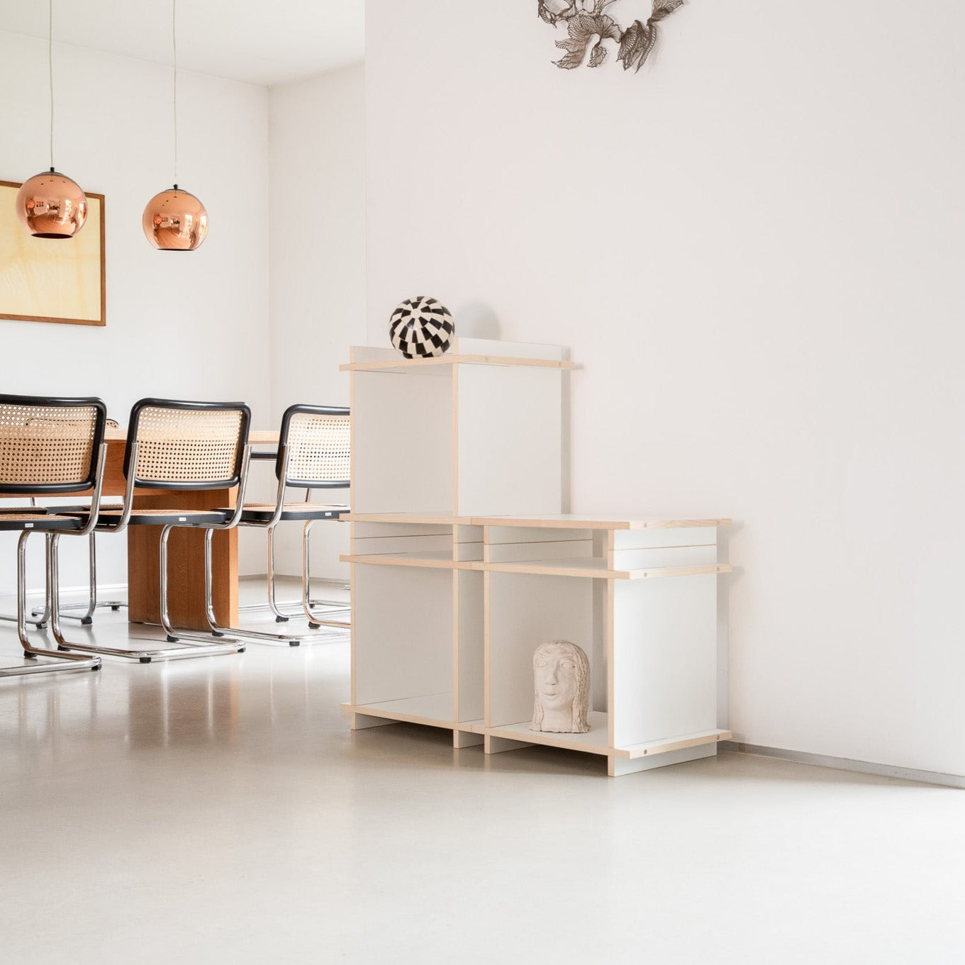 Regal mit Büchern bestehend aus schwarzen Würfeln in einem moderenen Raum.