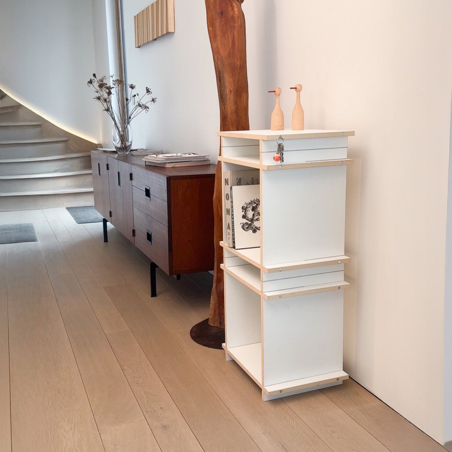 Regalsystem aufgebaut als modulares Regal oder hohes Würfelregal in Farbe white. In einem modernen skandinavischem Wohnzimmer und Flur.