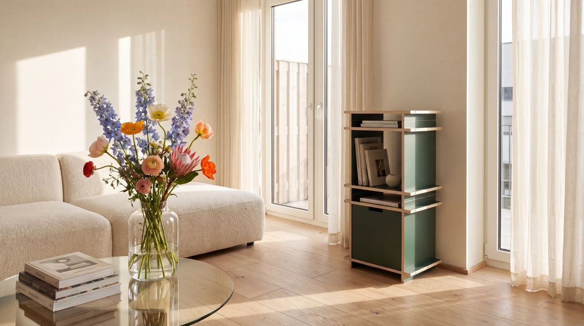 Schmale Konsole von Kiyo in Green aus zwei Cubes mit Box L und Büchern im hellen Wohnzimmer am Fenster.