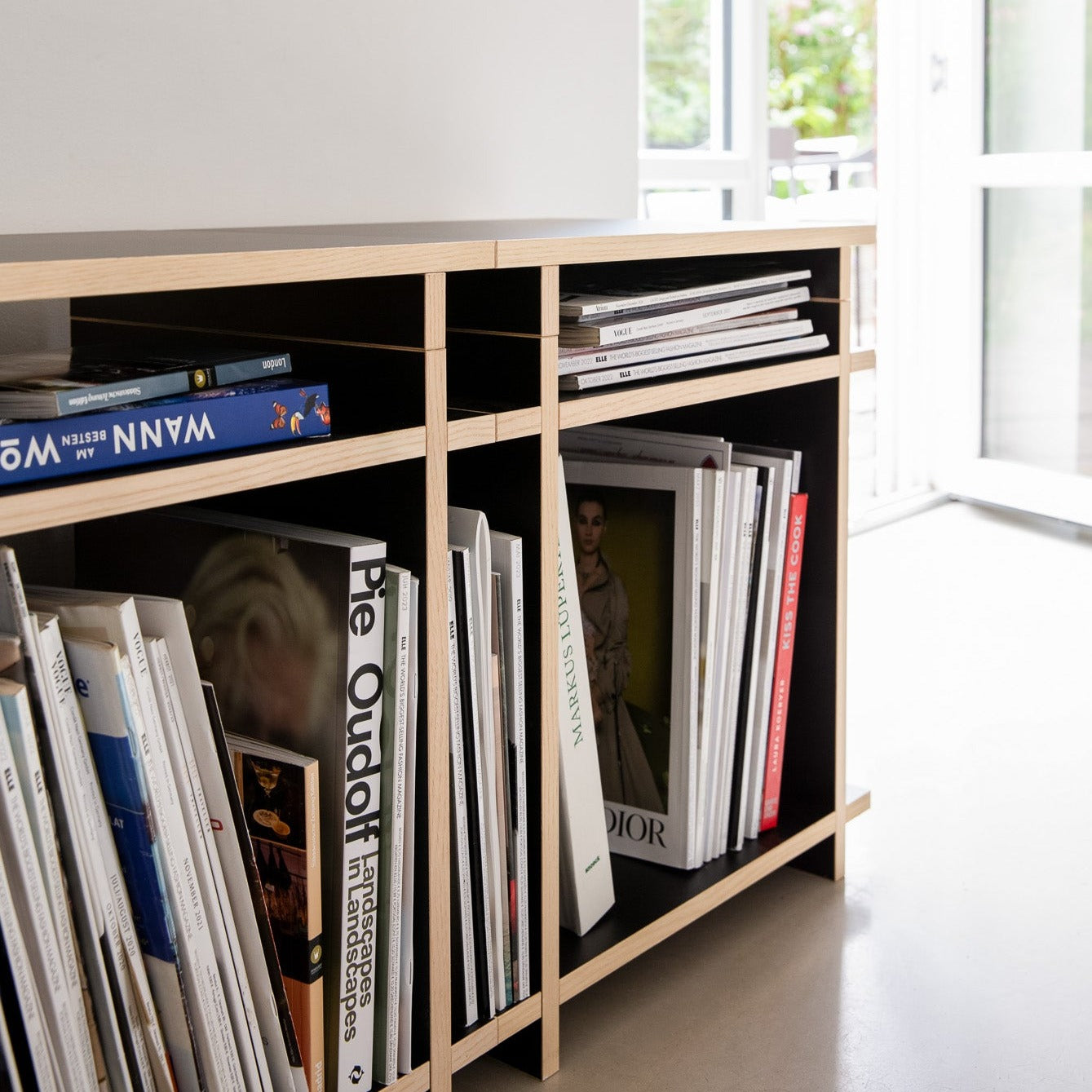 Detail eines Sideboards mit Büchern bestehend aus Regalwürfeln in einem modernen Raum. 