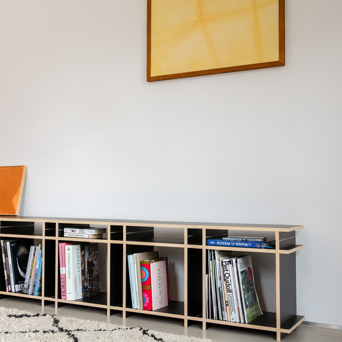 Sideboard mit Büchern bestehend aus Regalwürfeln in einem modernen Raum. 
