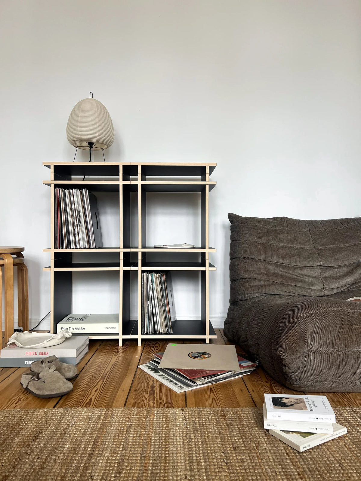 Schwarzer Aufbau eines Schallplattenregal bei der Creator:in @casadooni zuhause. Das Regal fügt sich perfekt in die moderne Wohnung mit japanischer Ästhetik. Und die Größe der Fächer ist perfekt auf Schallplatten ausgelegt.  