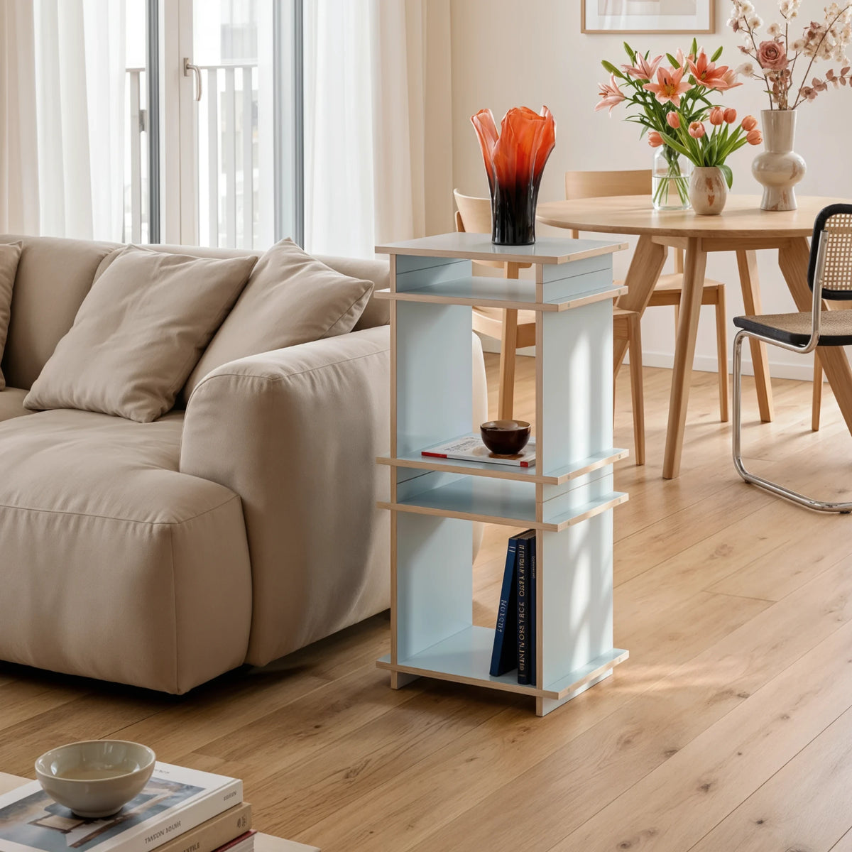 R1 Entry Bundle in Blau von Kiyo als schmales Regal im Wohnzimmer, mit Vase, Schale und Büchern.