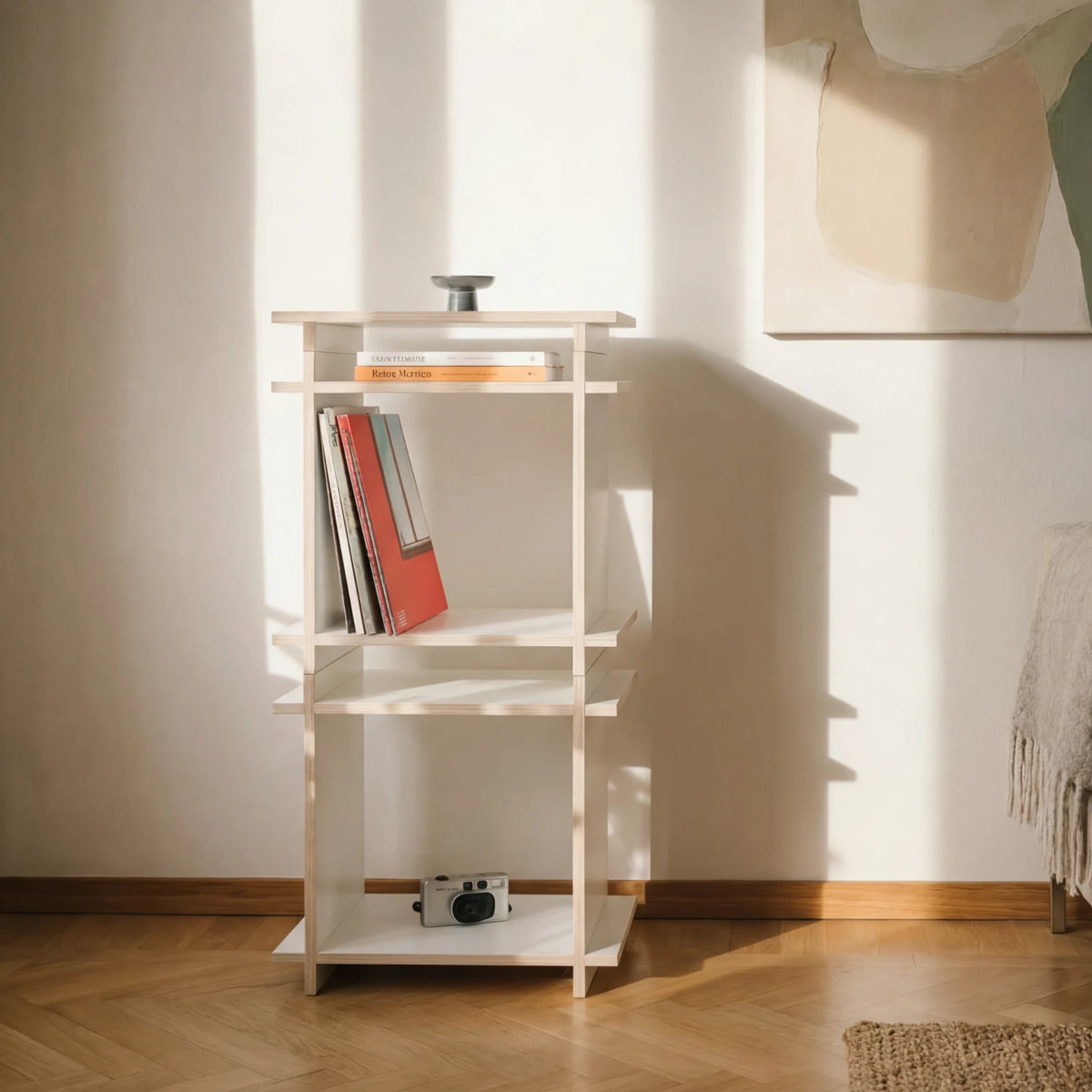 R1 Entry Bundle in Weiß von Kiyo als schmales Regal, mit Büchern, Schallplatten und Kamera im Sonnenlicht.