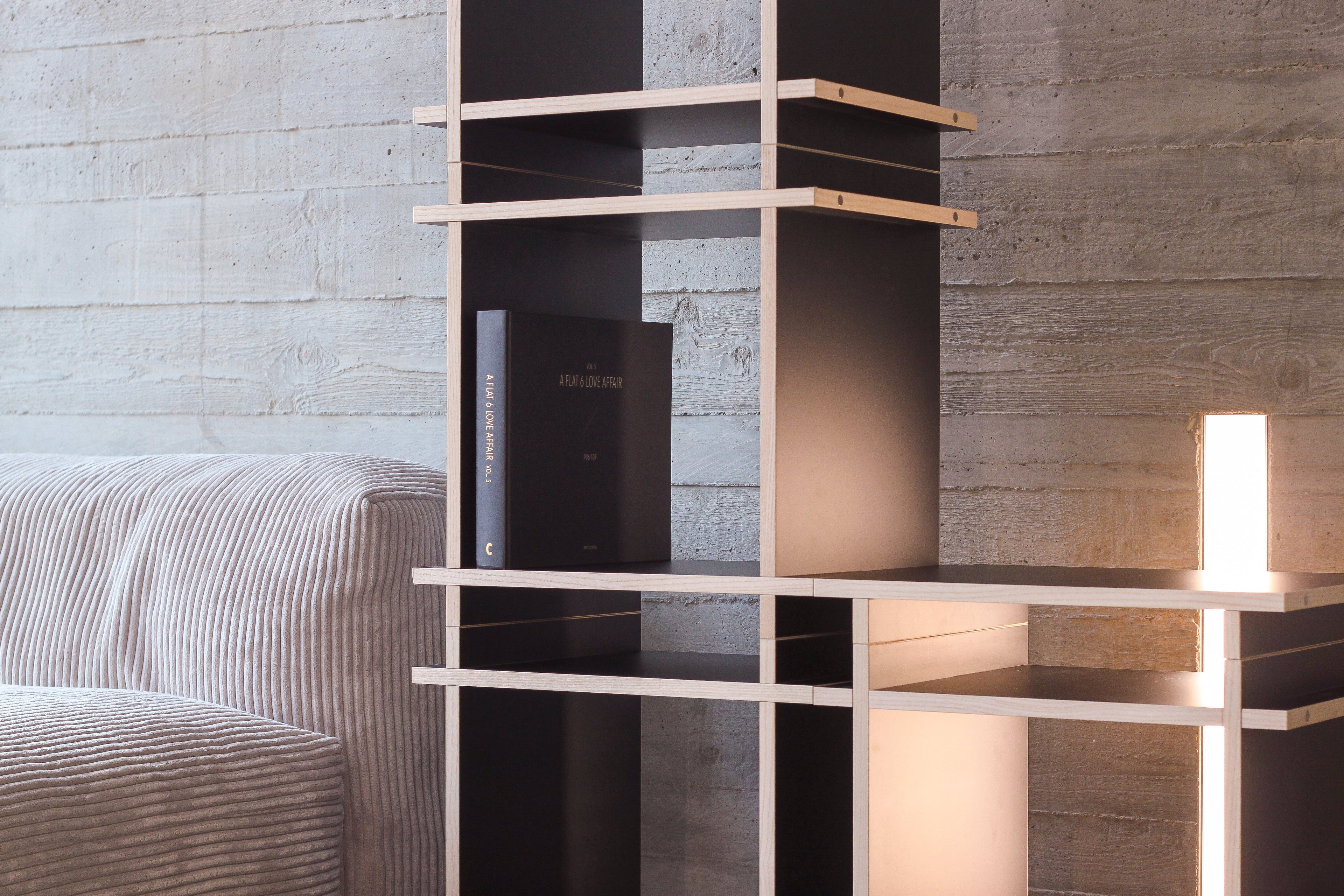 Regal in Farbe Schwarz aufgebaut als Sideboard in modernem Wohnzimmer.